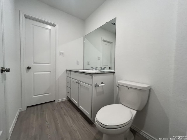 8823 Astral Pl, San Antonio, TX 78252 - half bathroom with vanity, baseboards, toilet, and wood finished floors