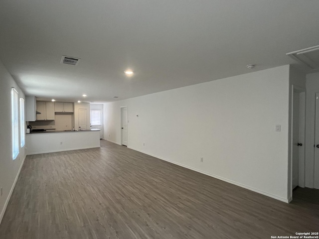 8823 Astral Pl, San Antonio, TX 78252 - unfurnished living room featuring visible vents, recessed lighting, baseboards, and dark wood-style floors