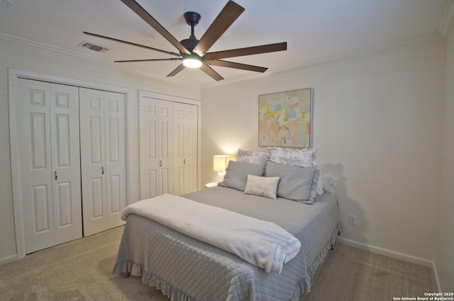 bedroom featuring carpet flooring, crown molding, multiple closets, a ceiling fan, and baseboards