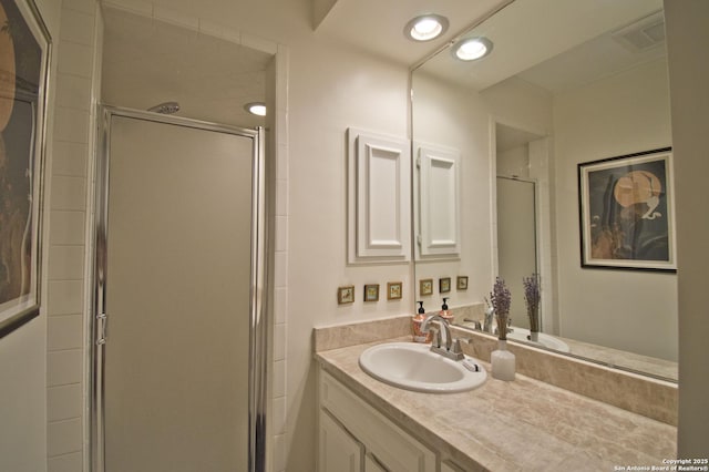 full bathroom featuring vanity, visible vents, and a shower stall