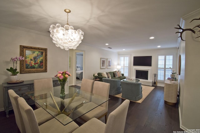 dining area featuring an inviting chandelier, crown molding, recessed lighting, and dark wood-type flooring