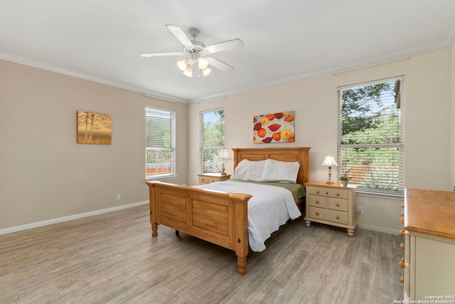 bedroom featuring baseboards, a ceiling fan, light wood-style flooring, and crown molding