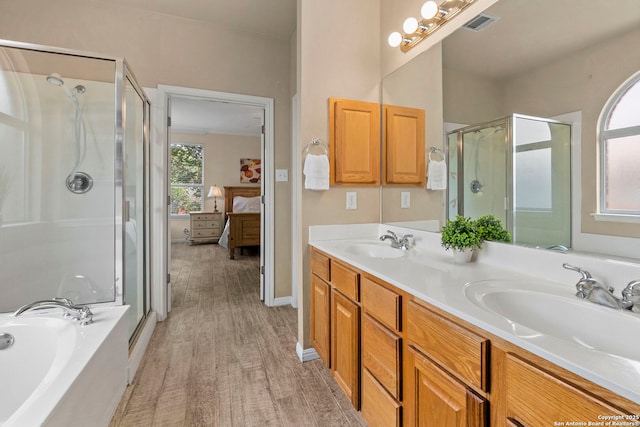 full bathroom with a sink, connected bathroom, wood finished floors, and a shower stall