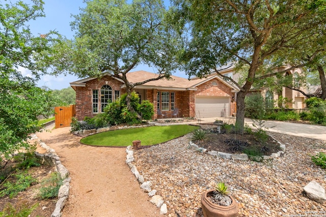 ranch-style home with brick siding, a garage, fence, and driveway