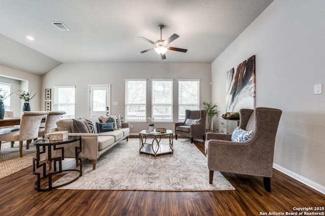 living area with a ceiling fan, baseboards, lofted ceiling, visible vents, and dark wood-style floors