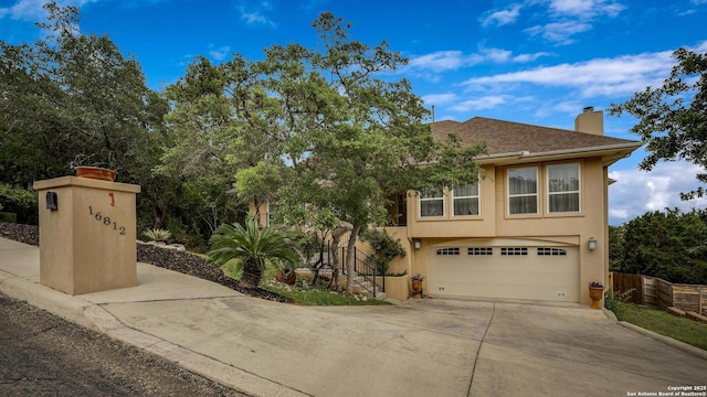 16812 Fox Rdg, Helotes, TX 78023 - view of front of property with fence, an attached garage, stucco siding, a chimney, and concrete driveway