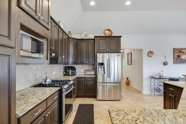 16812 Fox Rdg, Helotes, TX 78023 - kitchen with dark brown cabinets, backsplash, stainless steel appliances, and under cabinet range hood