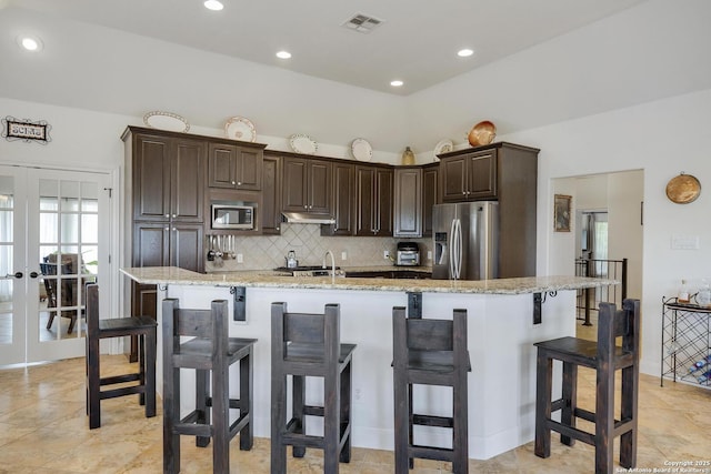 16812 Fox Rdg, Helotes, TX 78023 - kitchen with french doors, stainless steel appliances, decorative backsplash, under cabinet range hood, and visible vents