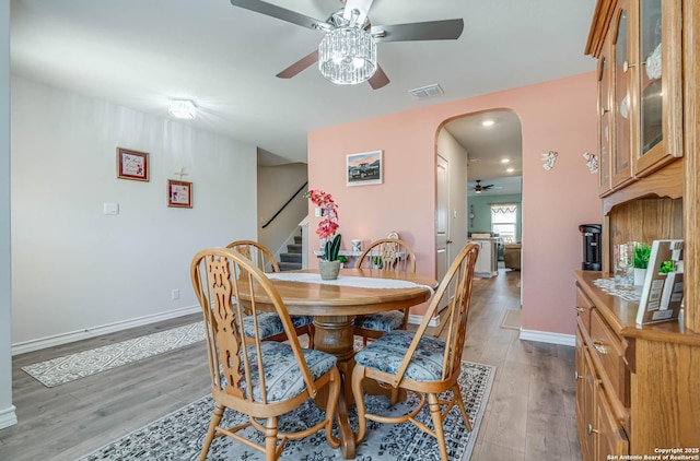 4704 Paluxy, San Antonio, TX 78253 - dining space featuring ceiling fan, visible vents, arched walkways, stairway, and light wood finished floors