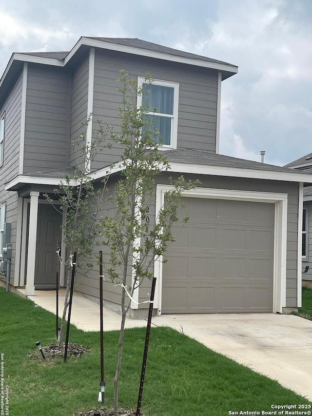 view of front of house with concrete driveway and a front lawn