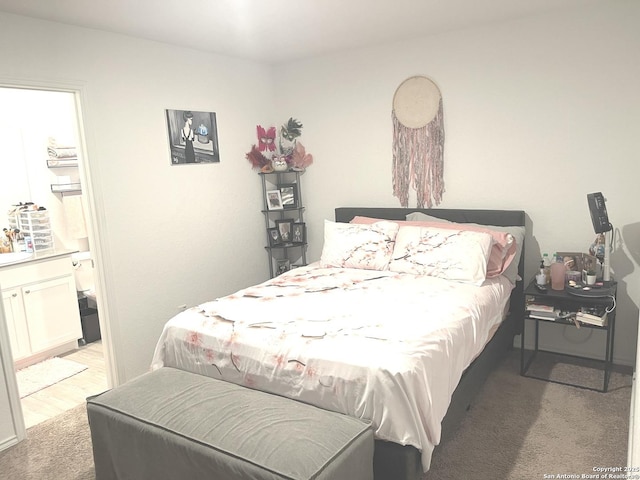 bedroom with light carpet and ensuite bath