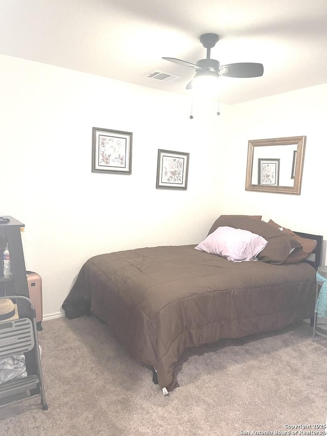 carpeted bedroom with a ceiling fan and visible vents