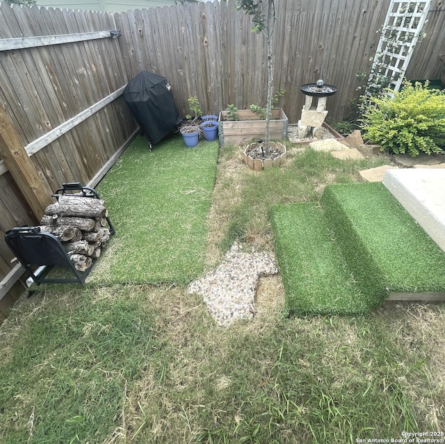 view of yard featuring fence and a vegetable garden