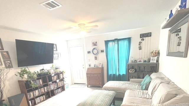 living area with ceiling fan and visible vents