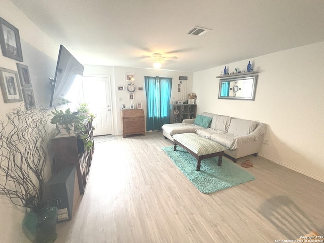 living room featuring baseboards, ceiling fan, wood finished floors, and visible vents