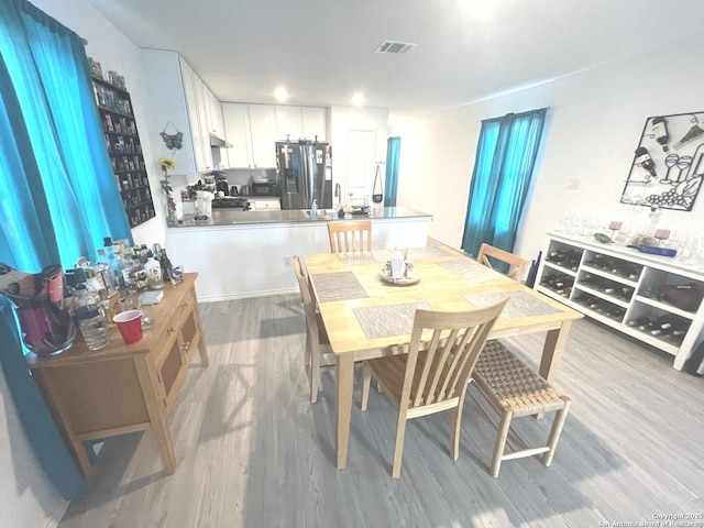dining space featuring visible vents and wood finished floors