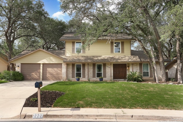 traditional-style house featuring a garage, a front lawn, a shingled roof, and concrete driveway