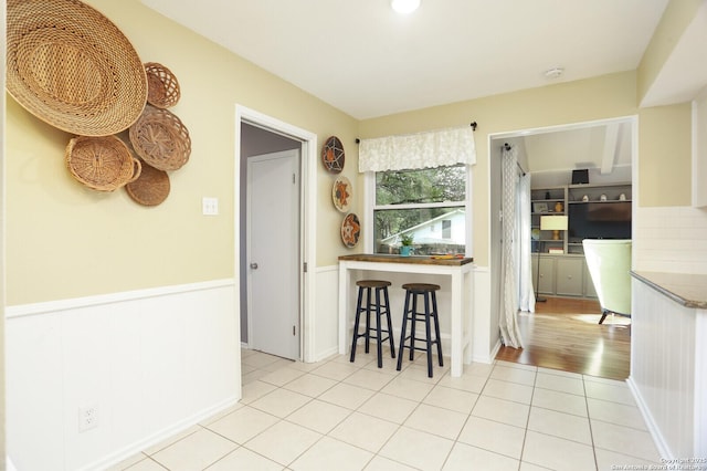 kitchen with wainscoting and light tile patterned floors