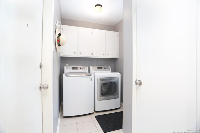 washroom with baseboards, cabinet space, light tile patterned floors, and washer and dryer
