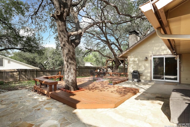 view of patio featuring a fenced backyard, a wooden deck, outdoor dining area, and a grill