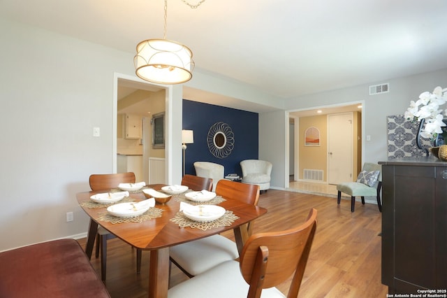 dining area featuring baseboards, visible vents, and light wood-style flooring