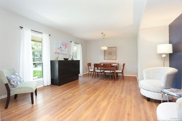 sitting room with baseboards and light wood-style floors