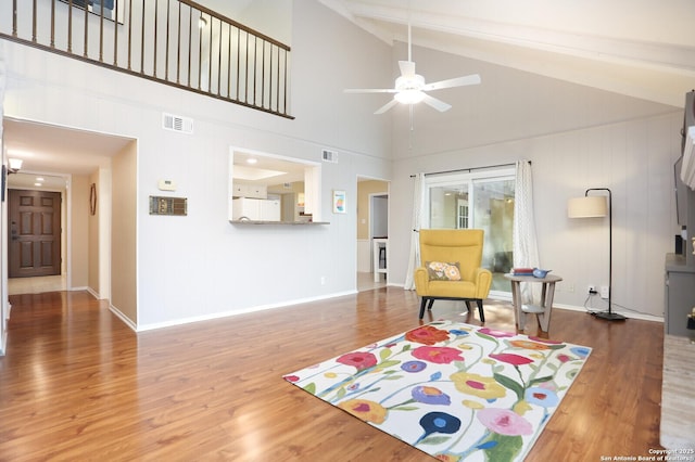 sitting room featuring a ceiling fan, beamed ceiling, visible vents, and wood finished floors
