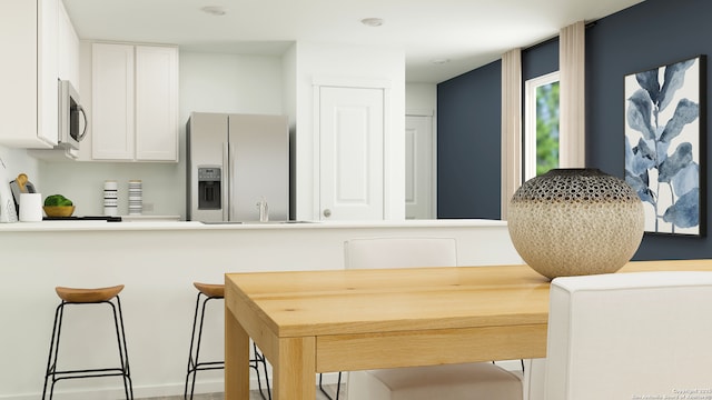 1045 Graham Bnd, San Antonio, TX 78221 - kitchen with light countertops, white cabinetry, stainless steel microwave, and fridge with ice dispenser