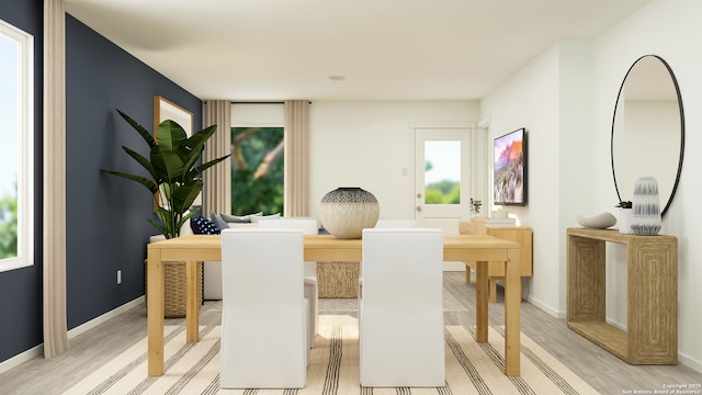 dining space with baseboards and light wood-style flooring