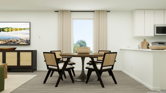 dining area featuring baseboards and light wood-type flooring