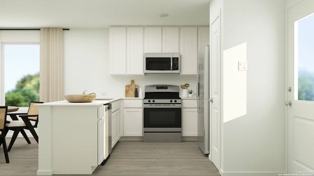 kitchen featuring a peninsula, light countertops, white cabinets, light wood finished floors, and stainless steel appliances