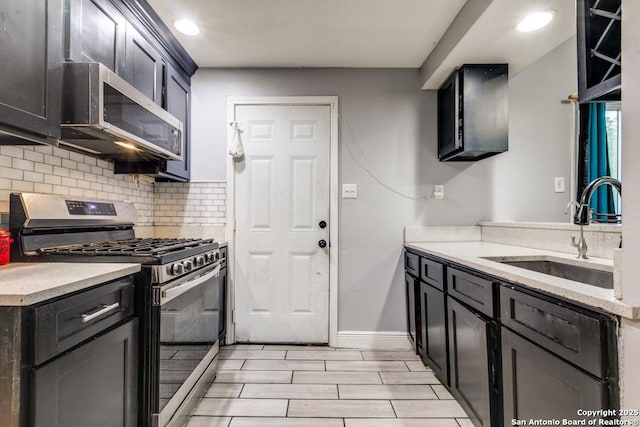 kitchen with wood tiled floor, recessed lighting, a sink, appliances with stainless steel finishes, and backsplash