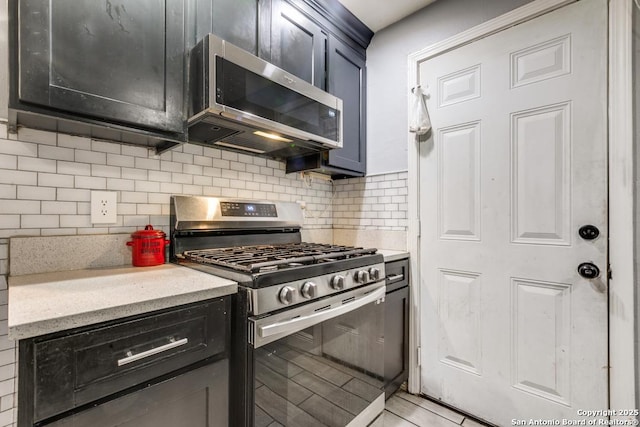 kitchen featuring light stone counters, decorative backsplash, and stainless steel appliances