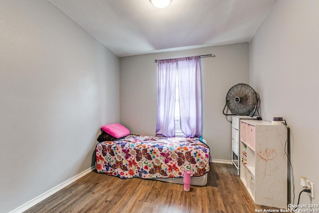 bedroom with baseboards and wood finished floors