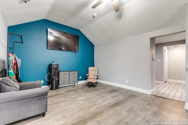 living area featuring baseboards, ceiling fan, vaulted ceiling, and wood finished floors
