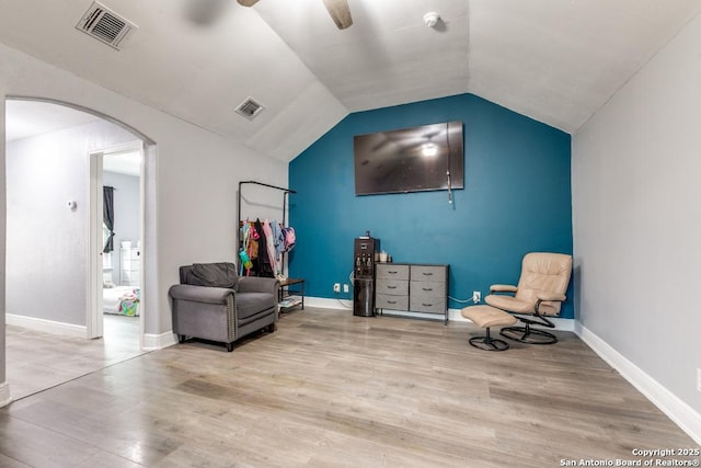 sitting room with visible vents, arched walkways, a ceiling fan, and wood finished floors