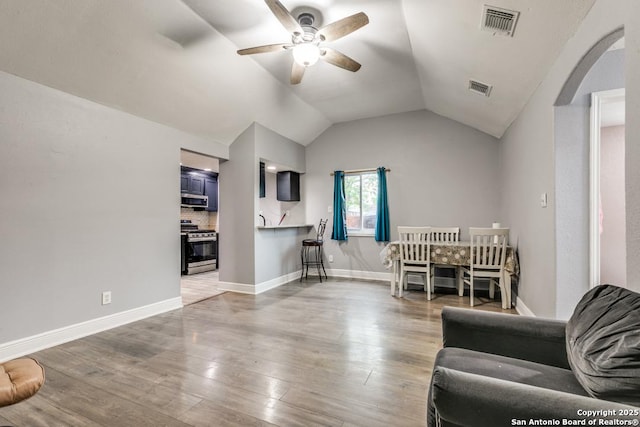living room with ceiling fan, visible vents, light wood finished floors, and lofted ceiling