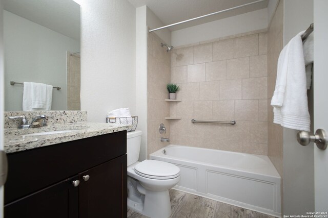 full bath featuring vanity, bathtub / shower combination, toilet, and wood finished floors
