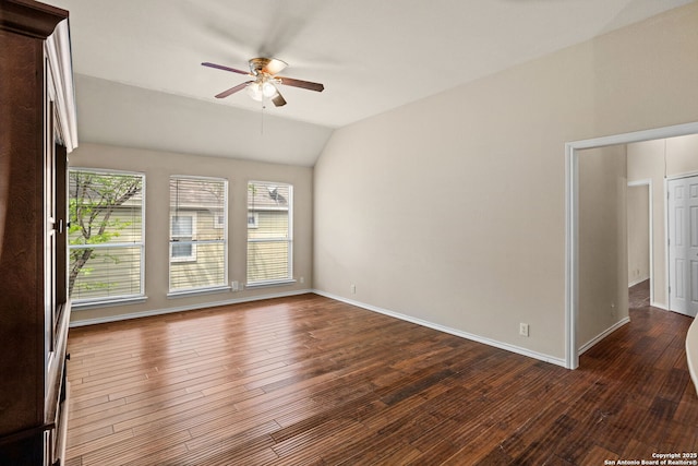 empty room with baseboards, ceiling fan, vaulted ceiling, and wood finished floors