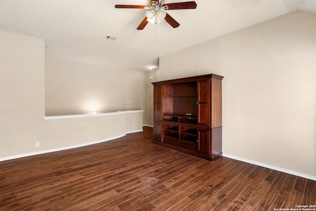 spare room with a ceiling fan, visible vents, dark wood finished floors, and vaulted ceiling