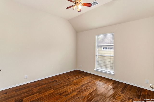 empty room featuring visible vents, baseboards, ceiling fan, dark wood finished floors, and vaulted ceiling
