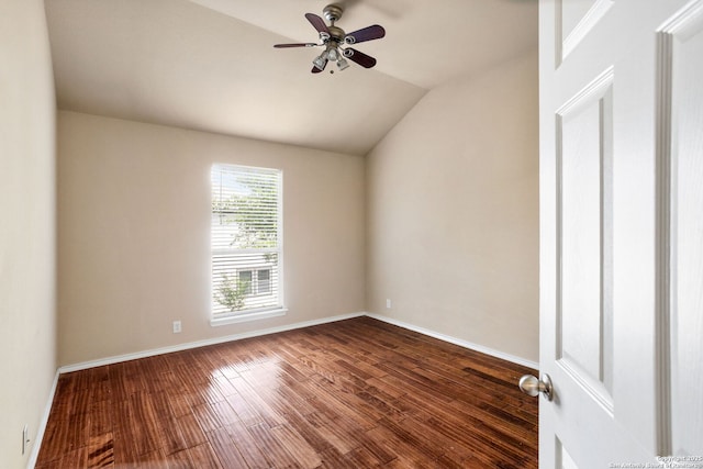 spare room with dark wood-style flooring, ceiling fan, vaulted ceiling, and baseboards