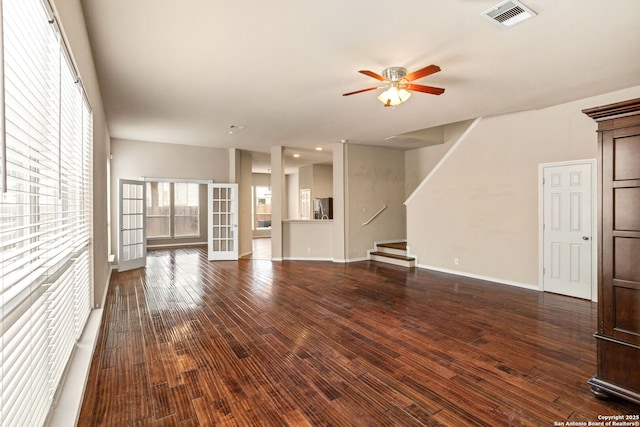unfurnished living room featuring stairs, a ceiling fan, visible vents, and wood finished floors