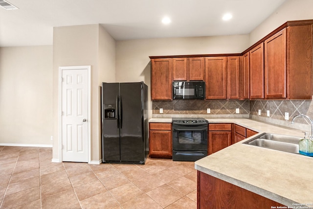 kitchen with visible vents, brown cabinetry, tasteful backsplash, a sink, and black appliances
