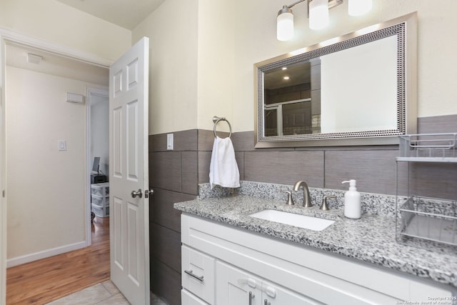 202 Beverly Dr, San Antonio, TX 78228 - bathroom with vanity, decorative backsplash, baseboards, and wood finished floors