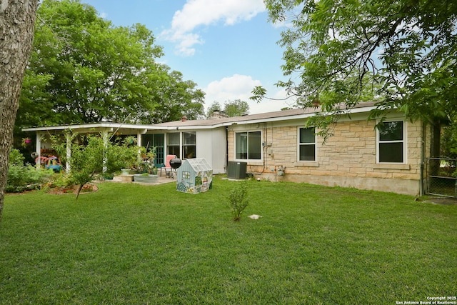 202 Beverly Dr, San Antonio, TX 78228 - back of house with central air condition unit, a yard, a patio area, and stone siding
