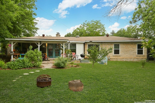 202 Beverly Dr, San Antonio, TX 78228 - rear view of house with a fire pit, stone siding, a chimney, a patio area, and a yard
