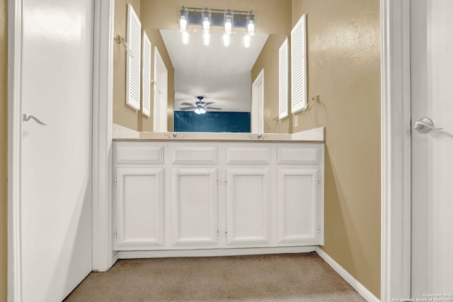 bathroom featuring double vanity, ceiling fan, a sink, and carpet