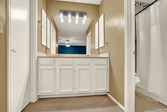 bathroom with double vanity, a sink, ceiling fan, and curtained shower