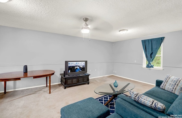 living area featuring carpet flooring, a textured ceiling, ceiling fan, and baseboards